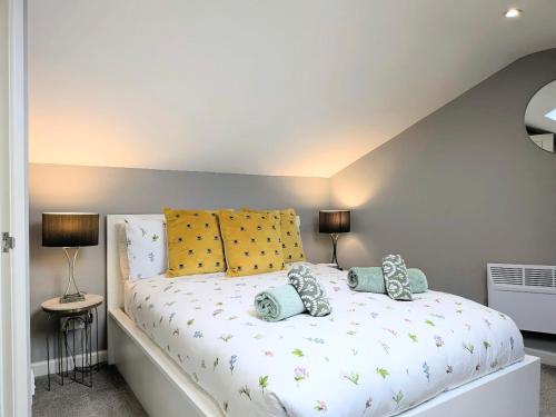 a bedroom with a white bed with yellow pillows at Old Yarn Apartment - Close to city walls in York