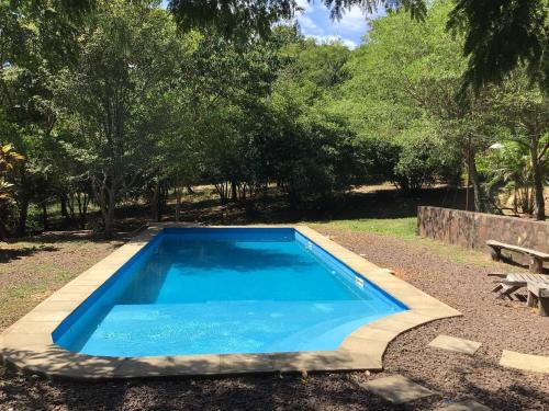 niebieski basen na podwórku z ławką w obiekcie Tranquilo Lodge & Camping w mieście La Colmena
