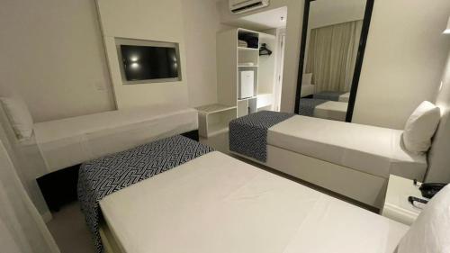 une petite chambre avec deux lits et un miroir dans l'établissement Nacional Inn Palmas, à Palmas
