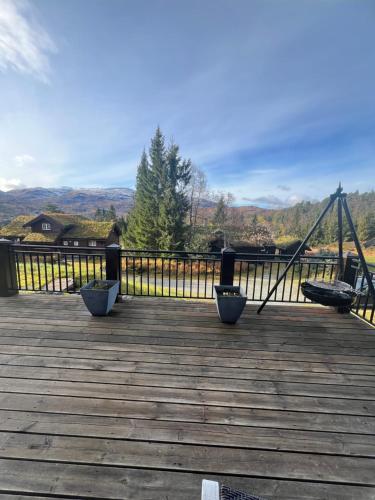 a wooden deck with a swing and a swing at Cabin in Kvamskogen in Kvam