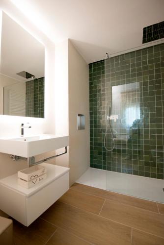 a bathroom with a sink and a shower with green tiles at Casa Iab in Arezzo