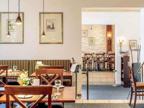 a restaurant with tables and chairs and a dining room at Mercure Hotel Erfurt Altstadt in Erfurt
