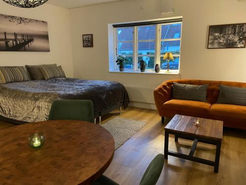 a living room with a bed and a couch and a table at Jonstrupvejens Apartments Lejl B in Ballerup