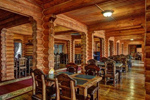 un comedor con mesas y sillas en una cabaña de madera en Hotel Hutorok, en Volgograd