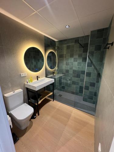 a bathroom with a toilet and a sink and a shower at CAROLINA CENTRO SUITEs in Monesterio
