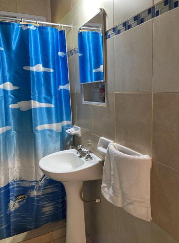 a bathroom with a sink and a shower curtain at Casa de playa Camping Chajarí in Santa Ana