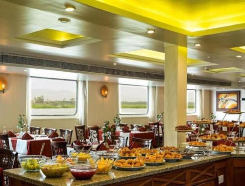 un restaurante con una línea de buffet con comida. en Nile Cruise FB 3 Nights Aswan Luxor, en Asuán