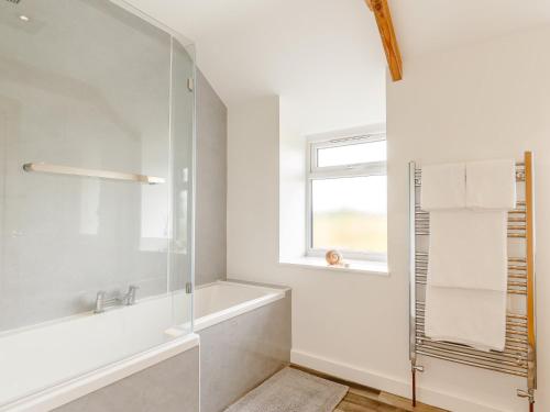 ニューリンにある1 Bed in Newlyn 78517の浴槽と窓のある白いバスルーム