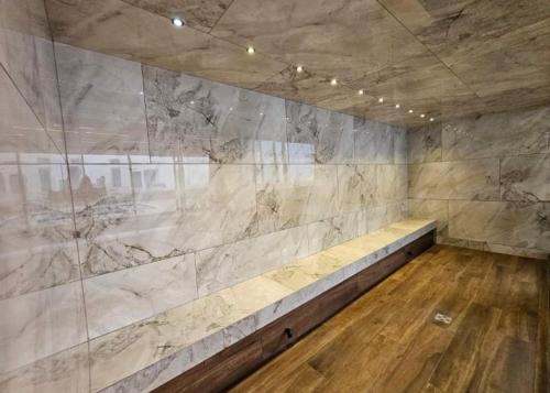 a room with a stone wall with a long bench at Sky Elite Depto de lujo in Santa Cruz de la Sierra