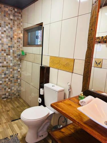 a bathroom with a toilet and a sink at Sanctuary Pirenópolis Suítes e Flats in Pirenópolis
