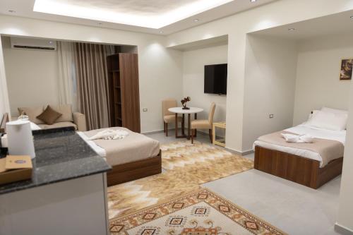 Una habitación de hotel con dos camas y cocina. en Arkan Hotel Qena, en Qinā