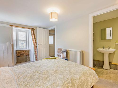 a bedroom with a bed and a sink at 3 Bed in Kirriemuir 37440 in Kirriemuir