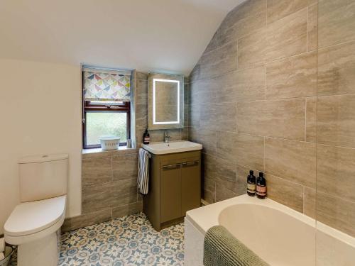 a bathroom with a tub and a toilet and a sink at 2 Bed in Ripon 88051 in Ripon
