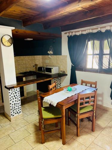 a kitchen with a wooden table and chairs in a kitchen at Departamentos Cachita in Carhué