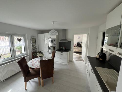 eine Küche mit Tisch und Stühlen und ein Esszimmer in der Unterkunft Villa Wohli 4 Sterne FERIENWOHNUNG AM HARZ in Nordhausen