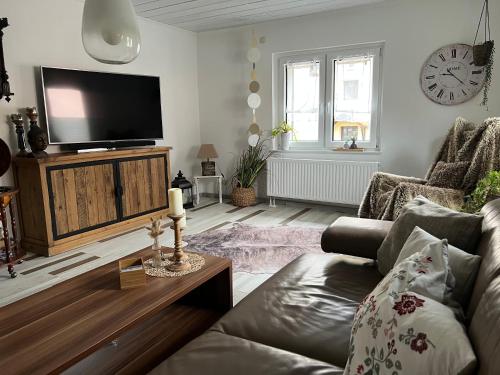 ein Wohnzimmer mit Couch und Flachbildfernseher in der Unterkunft Villa Wohli 4 Sterne FERIENWOHNUNG AM HARZ in Nordhausen