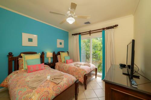 - une chambre avec 2 lits, une télévision et une fenêtre dans l'établissement Del Mar 2A 3 bdr Ocean View in Los Suenos, à Herradura