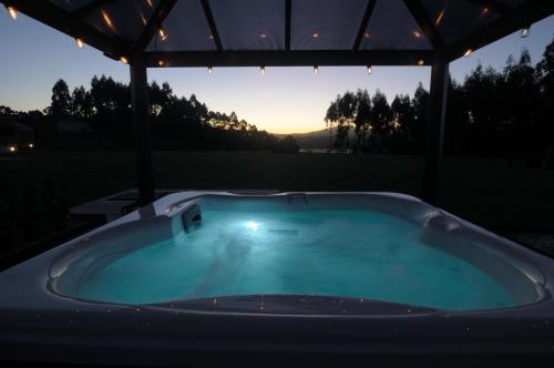 バレイロスにあるCabanas Da Barcelaの夕日を背景にしたガゼボの下の温水浴槽