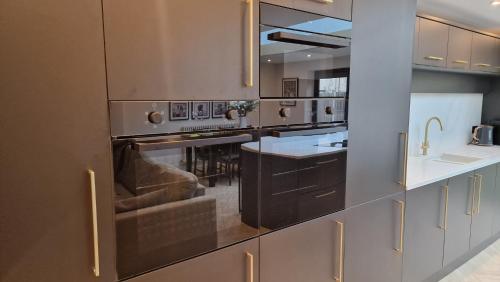 a kitchen with stainless steel appliances and a counter at Birkdale Open - modern 3 bedroom family home in Ainsdale