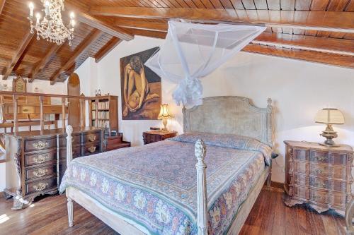 een slaapkamer met een bed en een kroonluchter bij Secluded House - Quinta La Rabide in Portinho da Arrábida