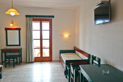 a waiting room with a bench and a table and a door at Dina's Diamond in Agios Prokopios