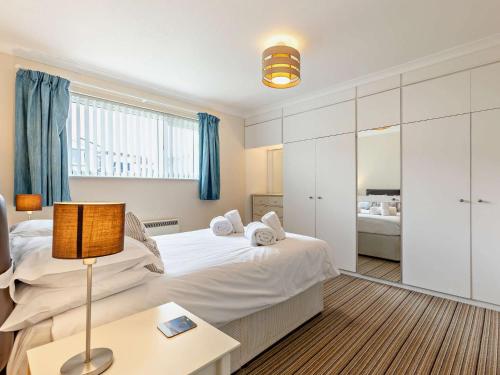 a bedroom with two beds and a table with a lamp at 2 Bed in Widemouth Bay 40636 in Marhamchurch