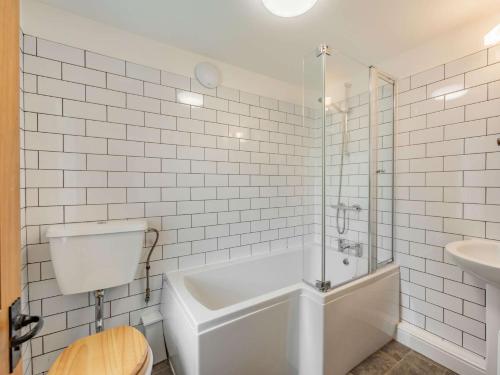 a white bathroom with a tub and a sink at 3 Bed in Northumberland National Park CN039 in Alwinton