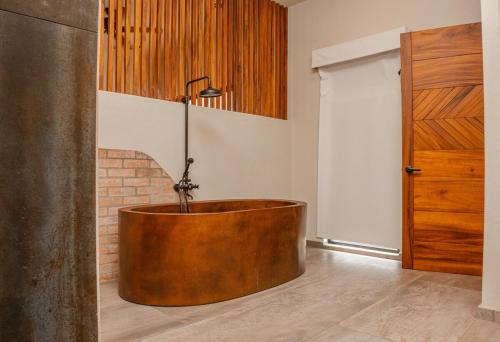 a wooden tub in a room with a door at The Garden Suite in El Rebalse