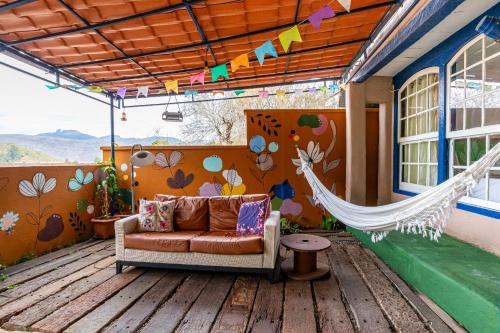 a porch with a couch and a hammock on a deck at É Hostel in Ouro Preto