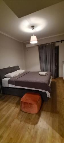 a bedroom with a bed and a ottoman at Eleusis modern flat,carpark in in Elefsina