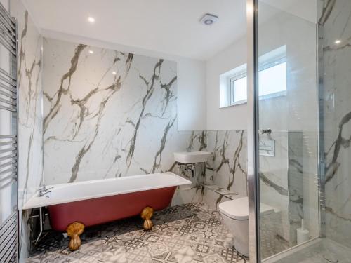 a bathroom with a bath tub and a toilet at 2 Bed in Stibbard 79993 in Stibbard