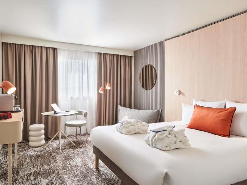 una habitación de hotel con una cama y un escritorio en Novotel Paris 13 Porte d'Italie, en Le Kremlin-Bicêtre
