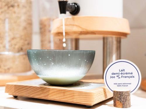 a bowl sitting on a cutting board next to a mixer at Novotel Paris 13 Porte d'Italie in Le Kremlin-Bicêtre