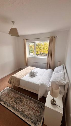 Un dormitorio con una cama blanca y una ventana. en 3 Bedroom Home, Wilton Hospital, en Cork