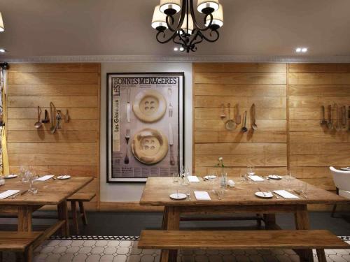 Un comedor con dos mesas y un cuadro de caras en la pared. en Sofitel Queenstown Hotel & Spa, en Queenstown