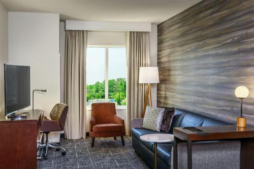 a hotel room with a couch and a desk at Residence Inn by Marriott Nashua in Nashua