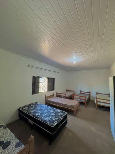 a room with two beds and a couch and a ceiling at Casa 12 camas empresas e grupos in Porto Alegre