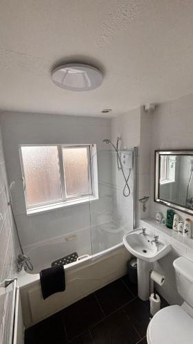 a bathroom with a tub and a sink and a toilet at Cardinal Court , Wilton 3BR Beside CUH Hospital in Cork