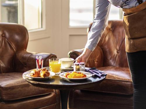 uma mesa com uma bandeja de comida e bebidas em Mercure Rambouillet Relays Du Château em Rambouillet
