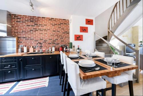 une cuisine avec une table en bois et des chaises blanches dans l'établissement Duplex Centre Historique, à Bordeaux