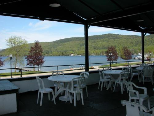 a patio with tables and chairs and a view of a lake at Fort William Henry Hotel in Lake George
