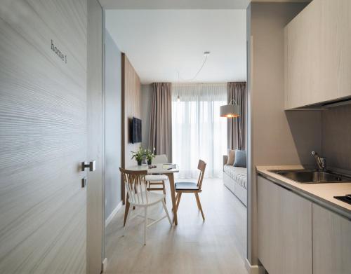 a kitchen and dining room with a table and chairs at Hatelier Garda Home by Enjoy Garda Hotel in Peschiera del Garda