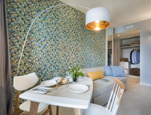 a living room with a white table and a couch at Hatelier Garda Home by Enjoy Garda Hotel in Peschiera del Garda