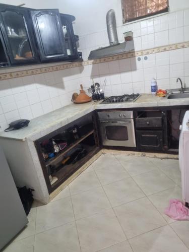 a kitchen with a stove and a sink in it at We'llcome home in Temara
