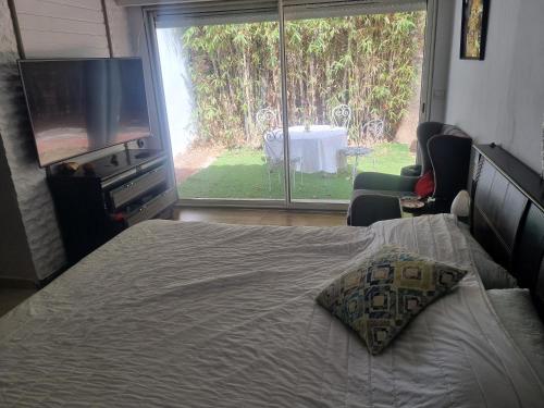 a bedroom with a bed and a television and a patio at We'llcome home in Temara