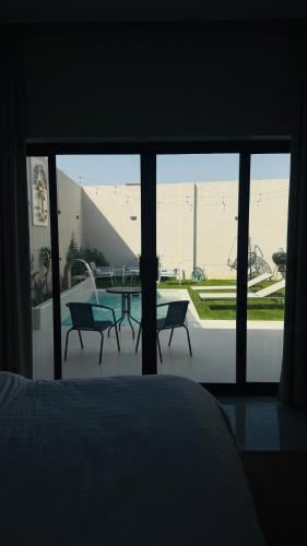 a bedroom with a view of a patio with a table and chairs at شاليهات بالما in Al Hofuf