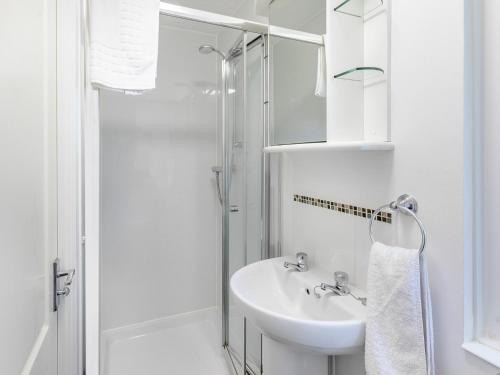 une salle de bain blanche avec un lavabo et une douche dans l'établissement 2 Bed in Dartmoor National Park 06200, à Okehampton