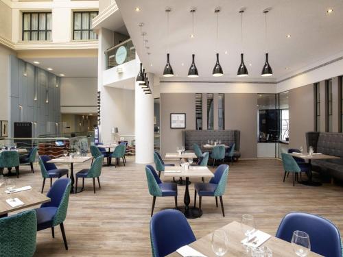 a dining room with tables and chairs and tablesktop at Sofitel London Gatwick in Horley