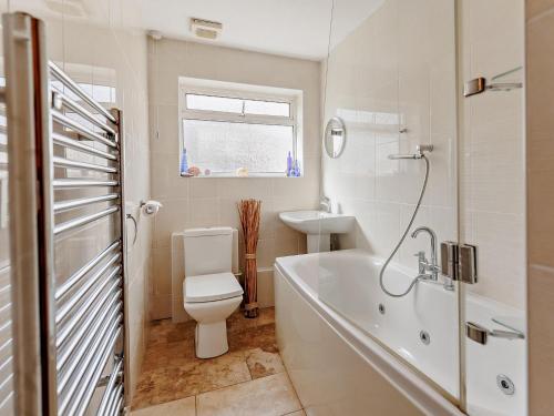 a bathroom with a tub and a toilet and a sink at 3 bed in Camber 72303 in Camber