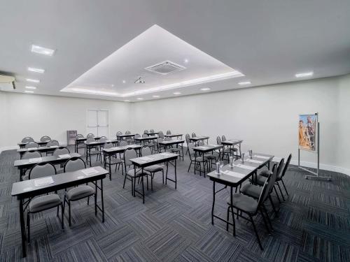a classroom with tables and chairs in a room at Mercure Sao Paulo Pamplona in Sao Paulo